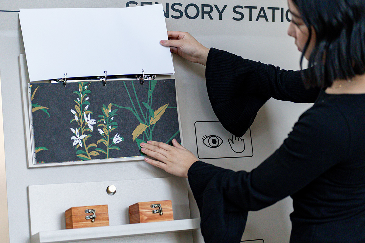 A person reaching out and touching samples of wallpaper mounted on rings
