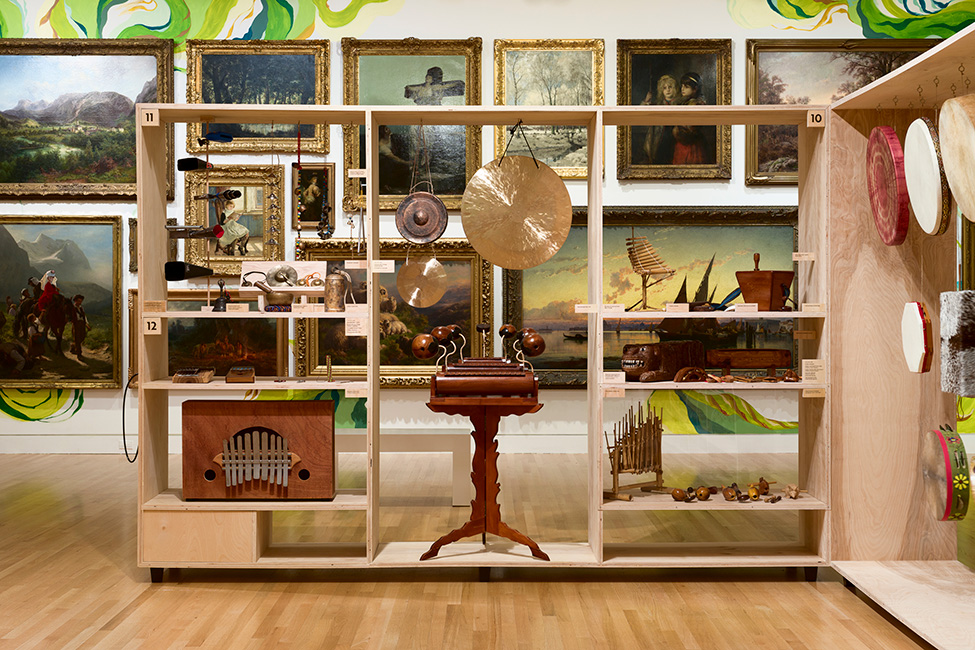 A view of instruments in the exhibition LINEAJES in front of the paintings of the Frye Salon