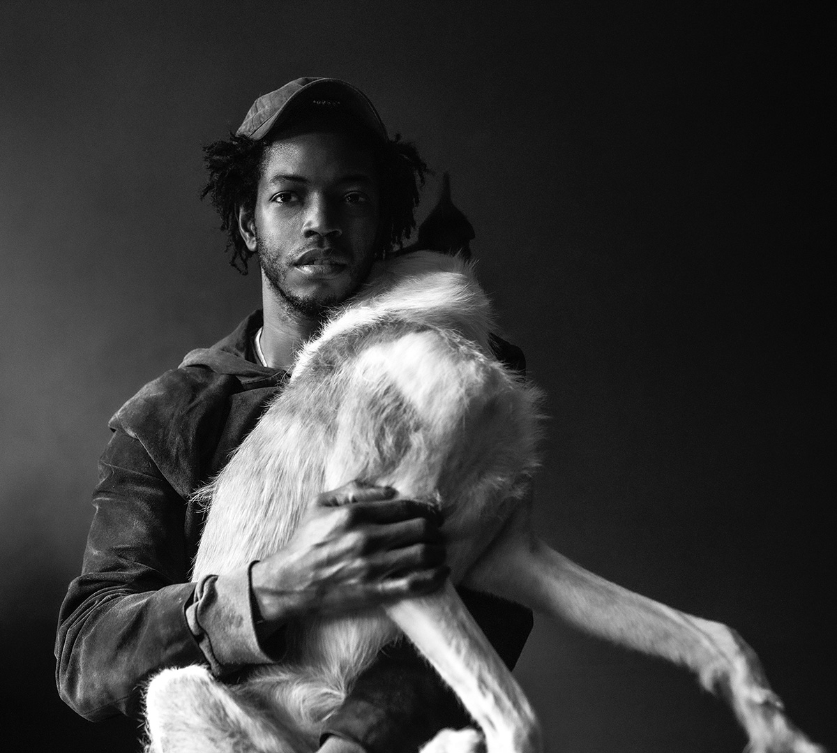 A black and white image of a man holding a dog