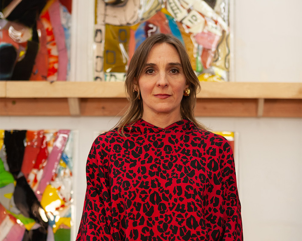 A photo of woman wearing a red and black dress looking at the camera