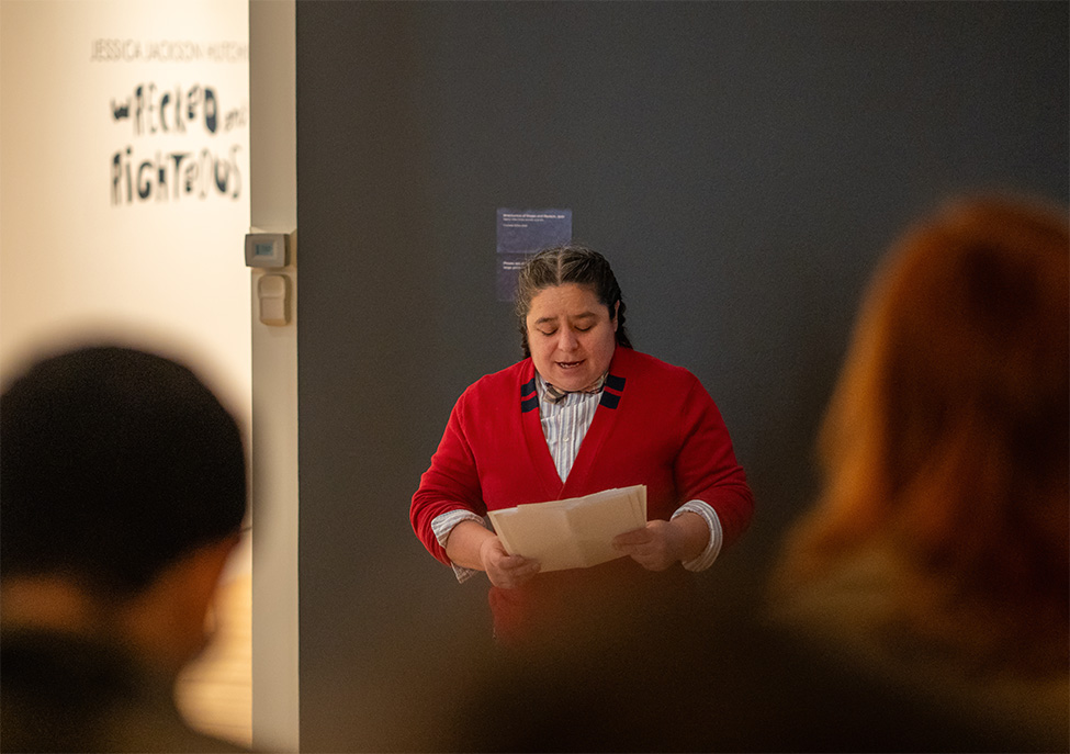 A person reading a poem in a gallery at the Frye Art Museum