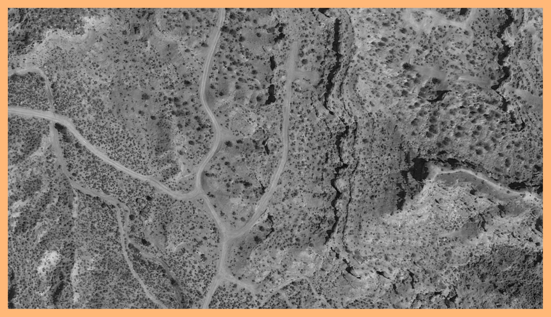 Black and white photograph of a mountain surface taken in Virgin, Utah. The image is surrounded by an orange border.