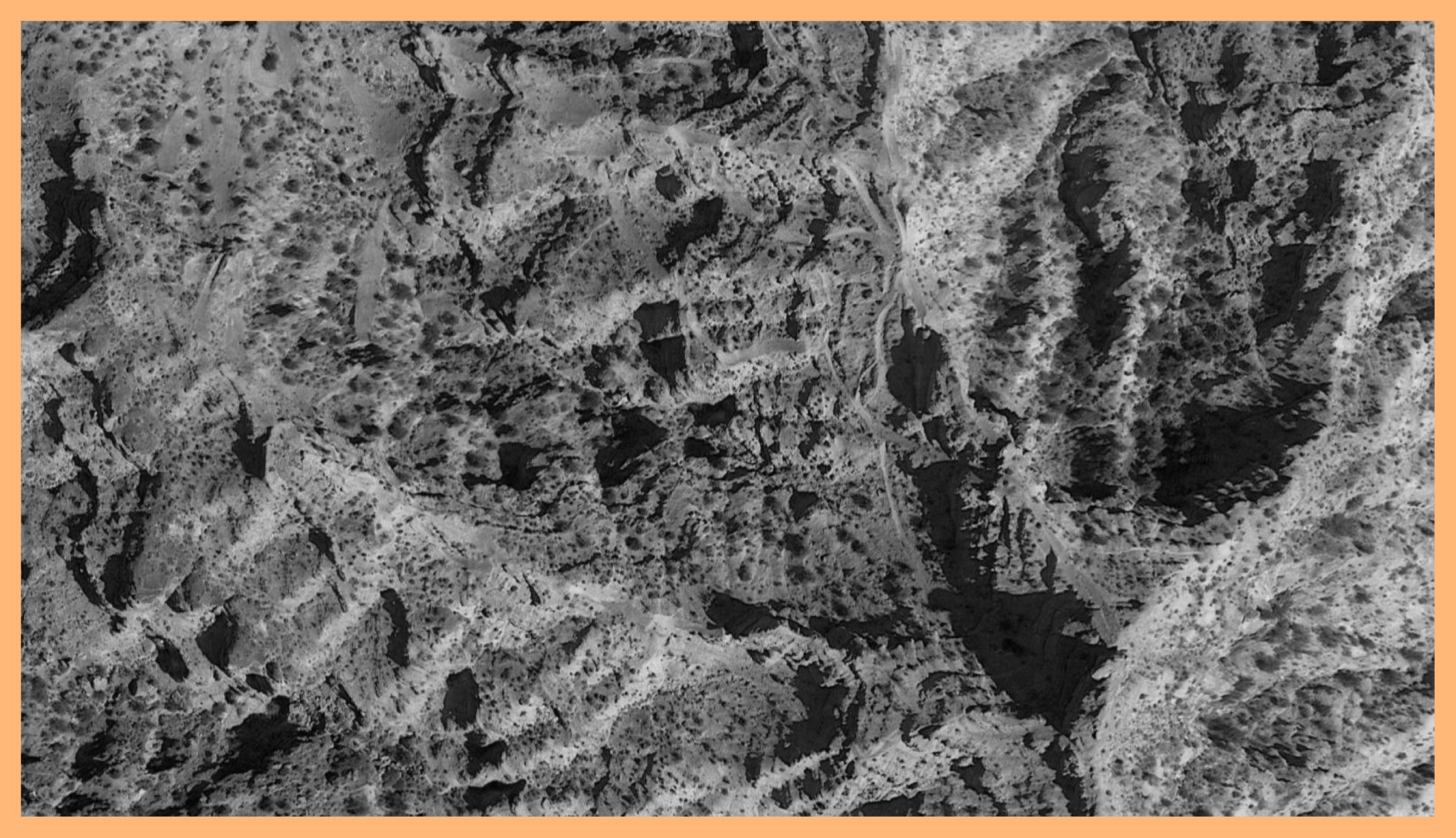 Black and white photograph of a mountain surface taken in Virgin, Utah. The image is surrounded by an orange border.