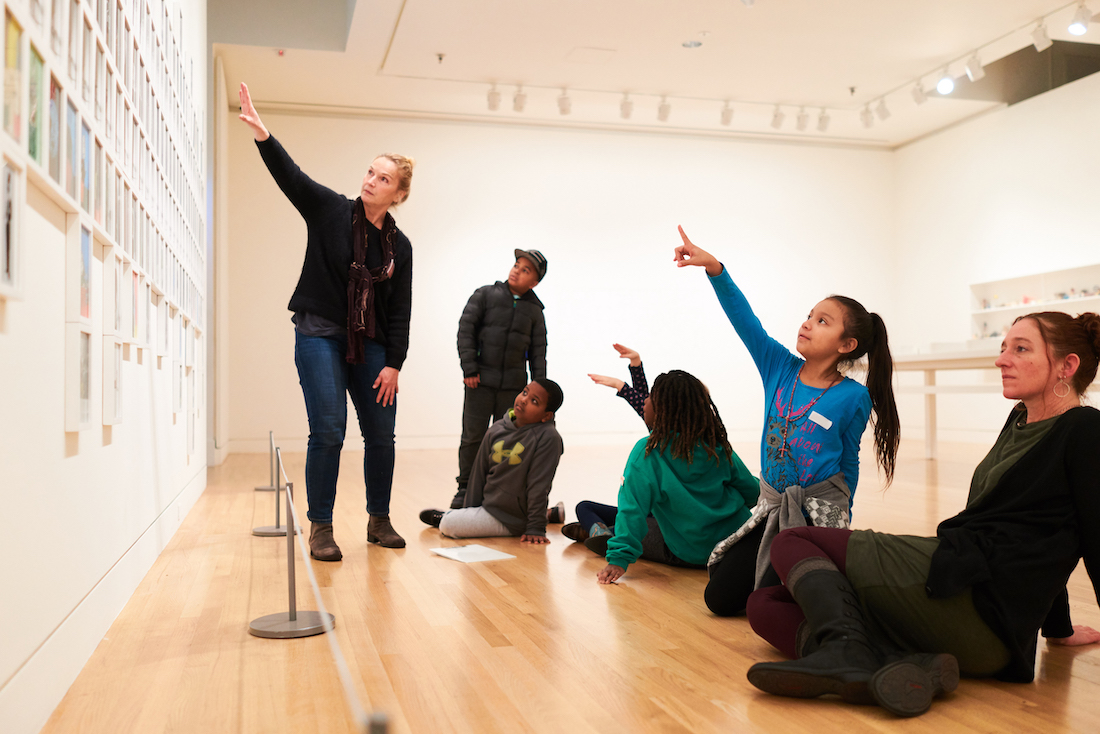 Students and docent looking at artwork in the Frye Art Museum galleries