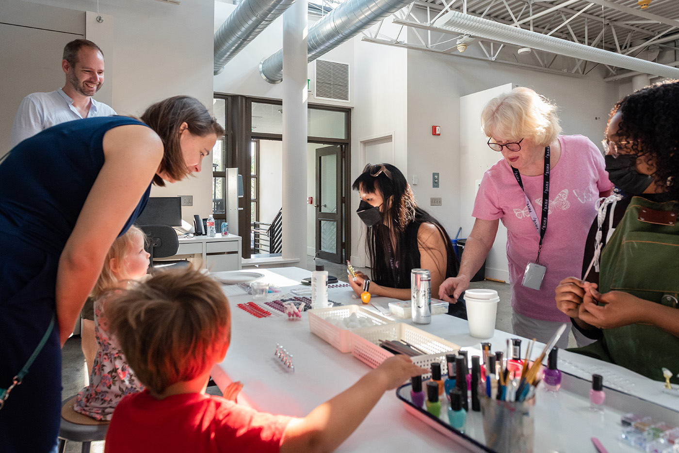 Children and adults selecting from craft supplies on a table