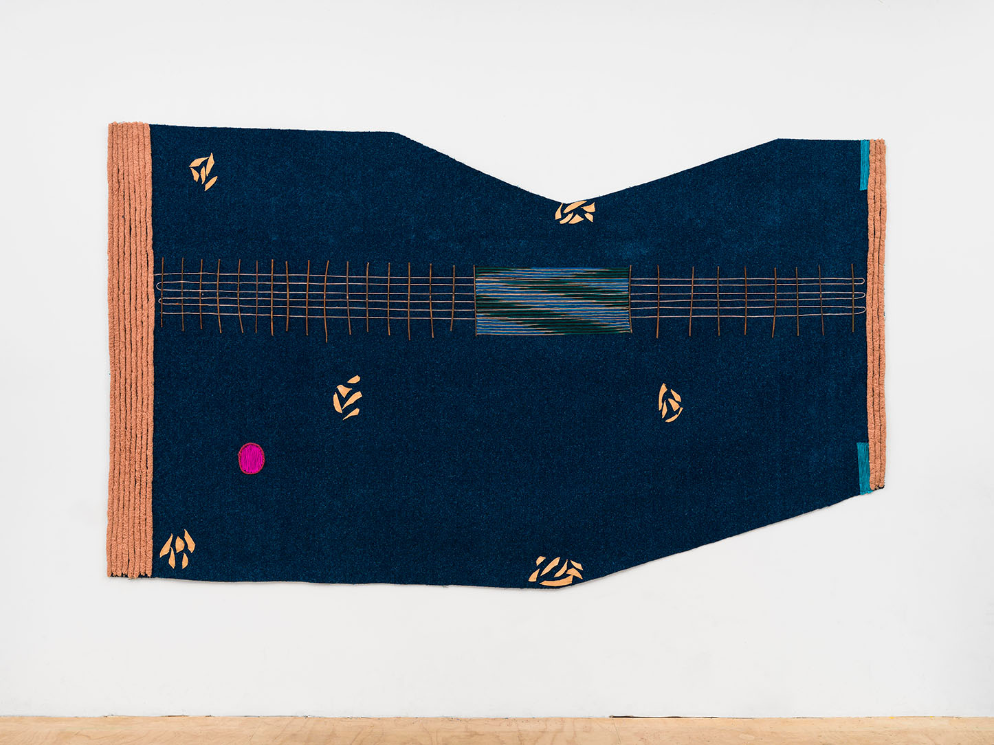 A large, fabric-based artwork hanging on a wall
