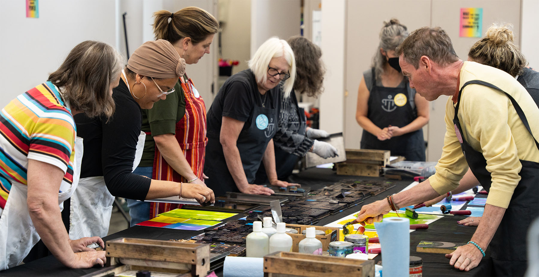 People gathered around a table working on art projects with letter blocks