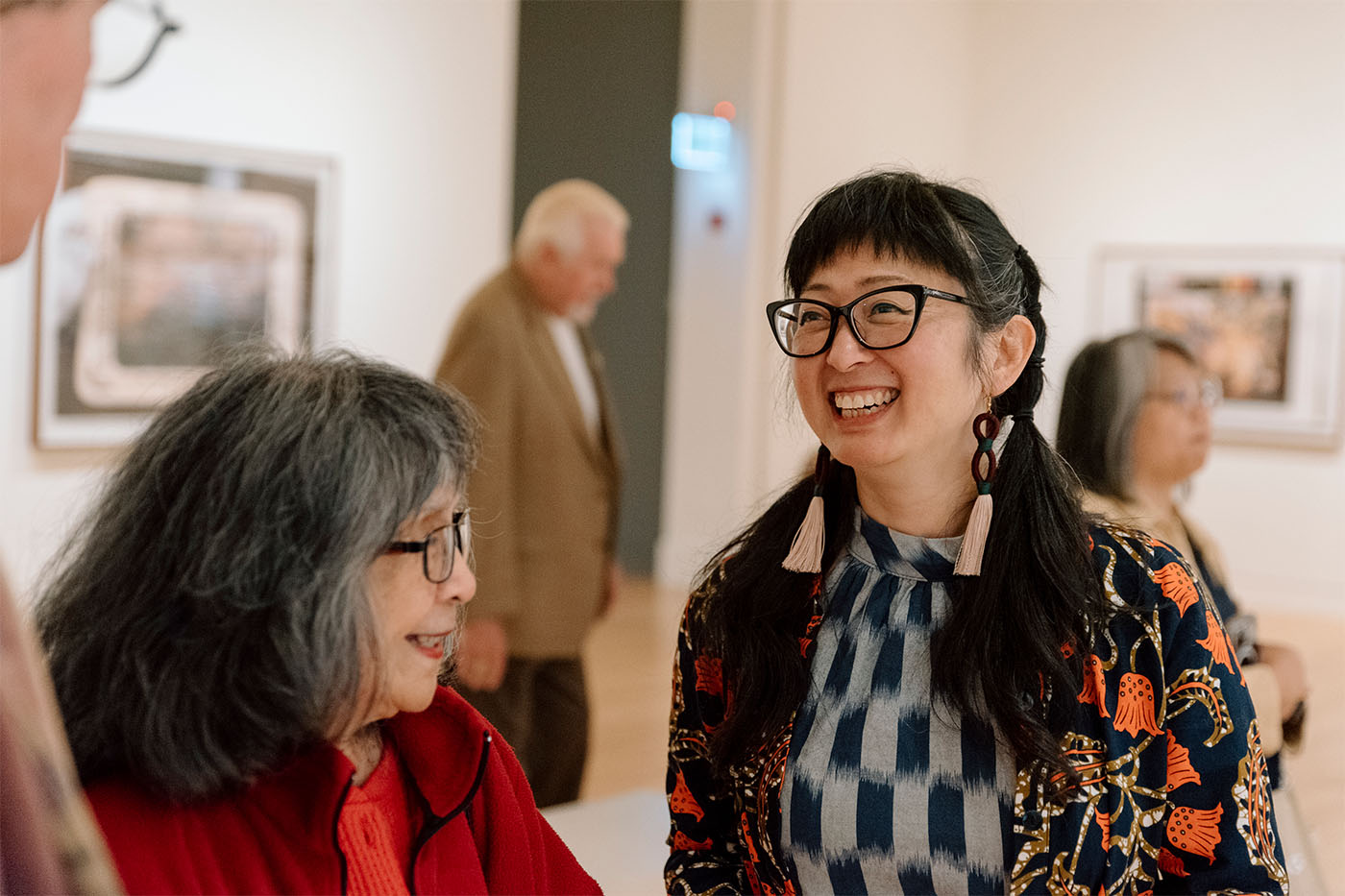 People smiling in conversation in a gallery