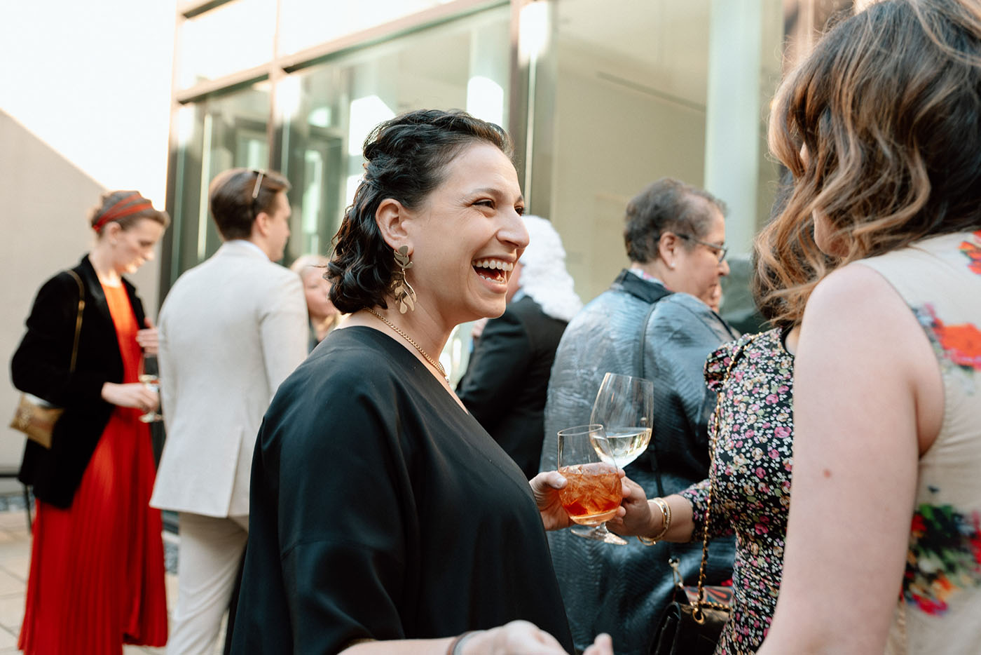 People smiling and holding drinks in the Frye Courtyard