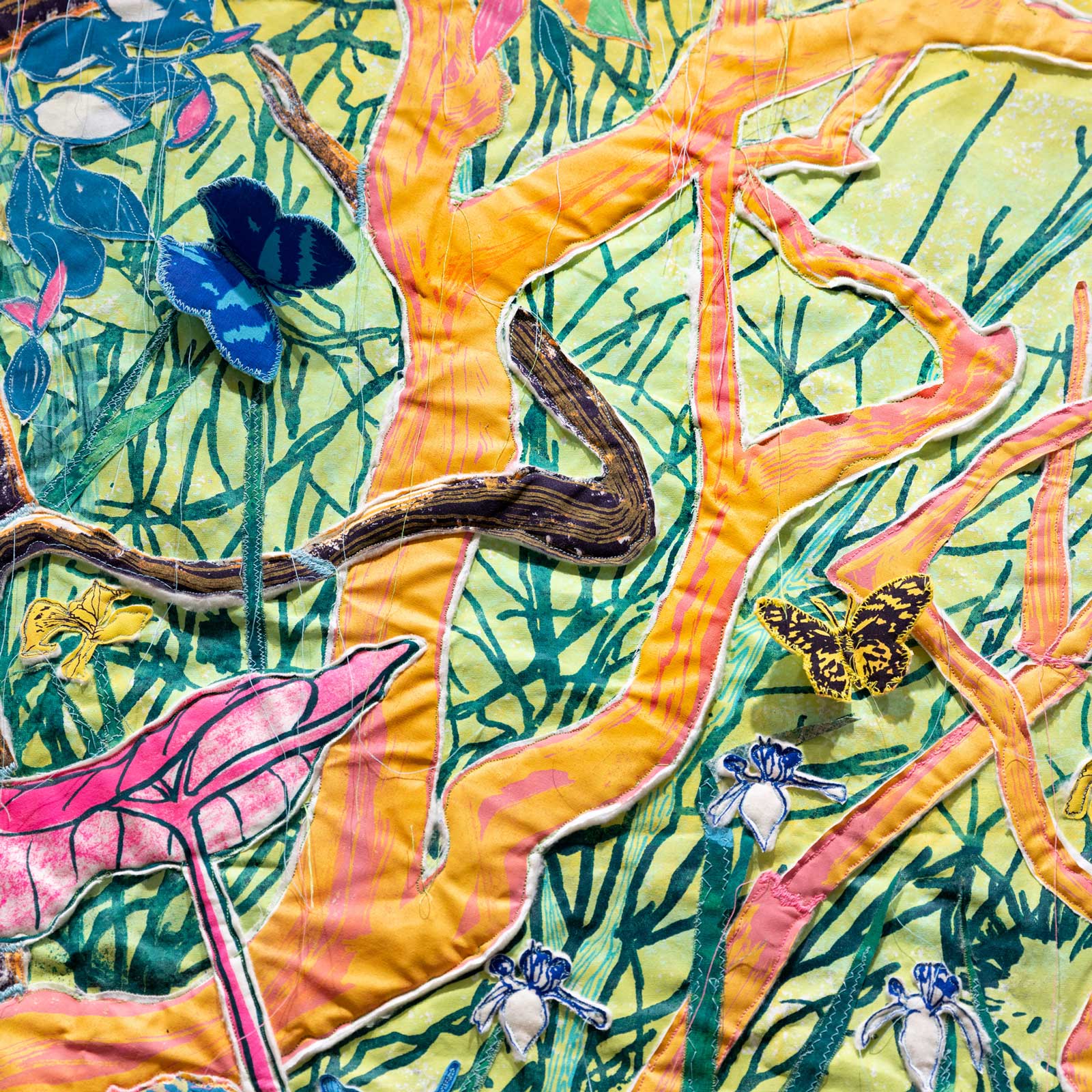 Detail of a colorful screenprinted tapestry with branches, flowers, and butterflies