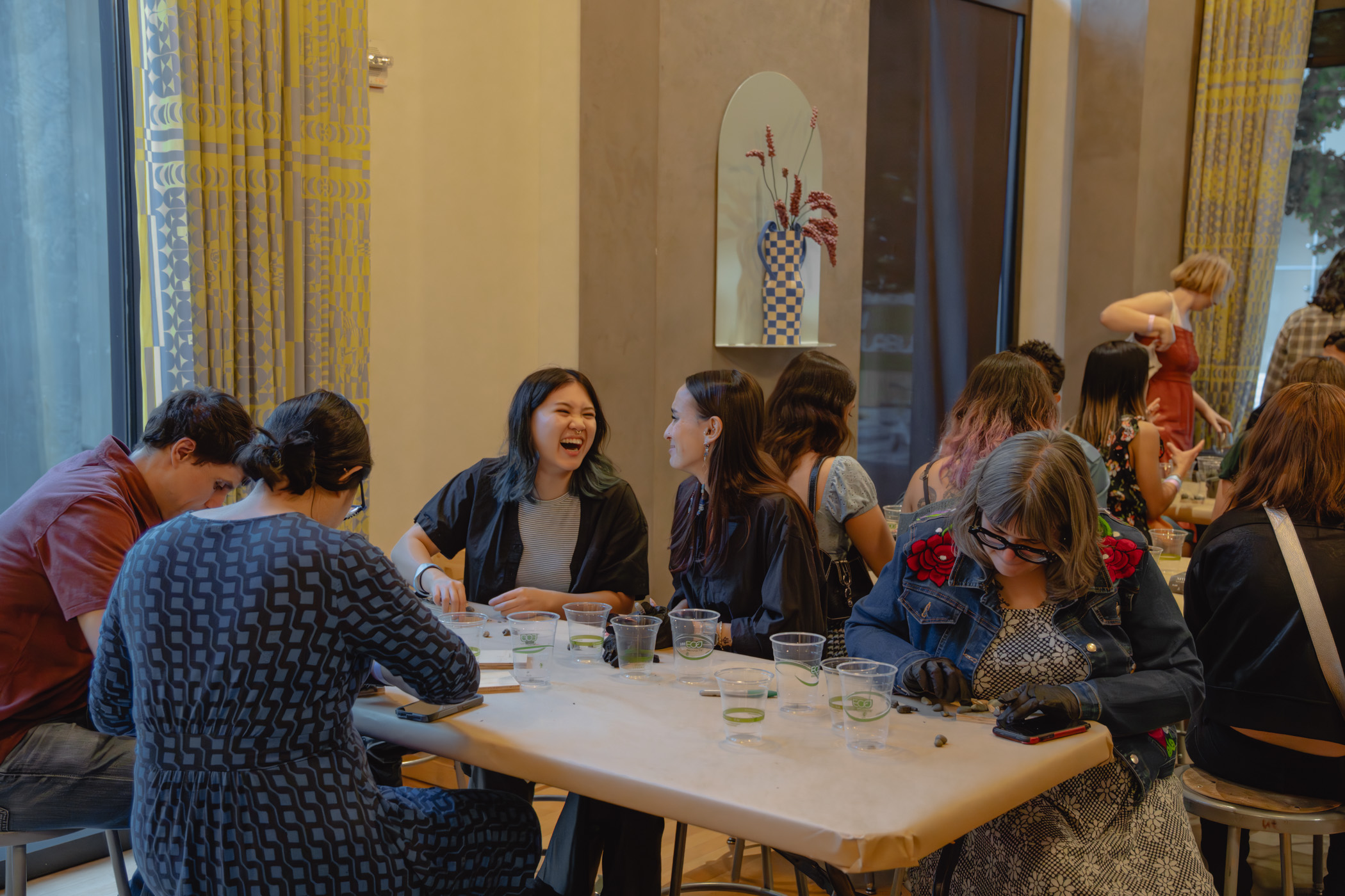 People seated at a table and chatting while working on an art activity