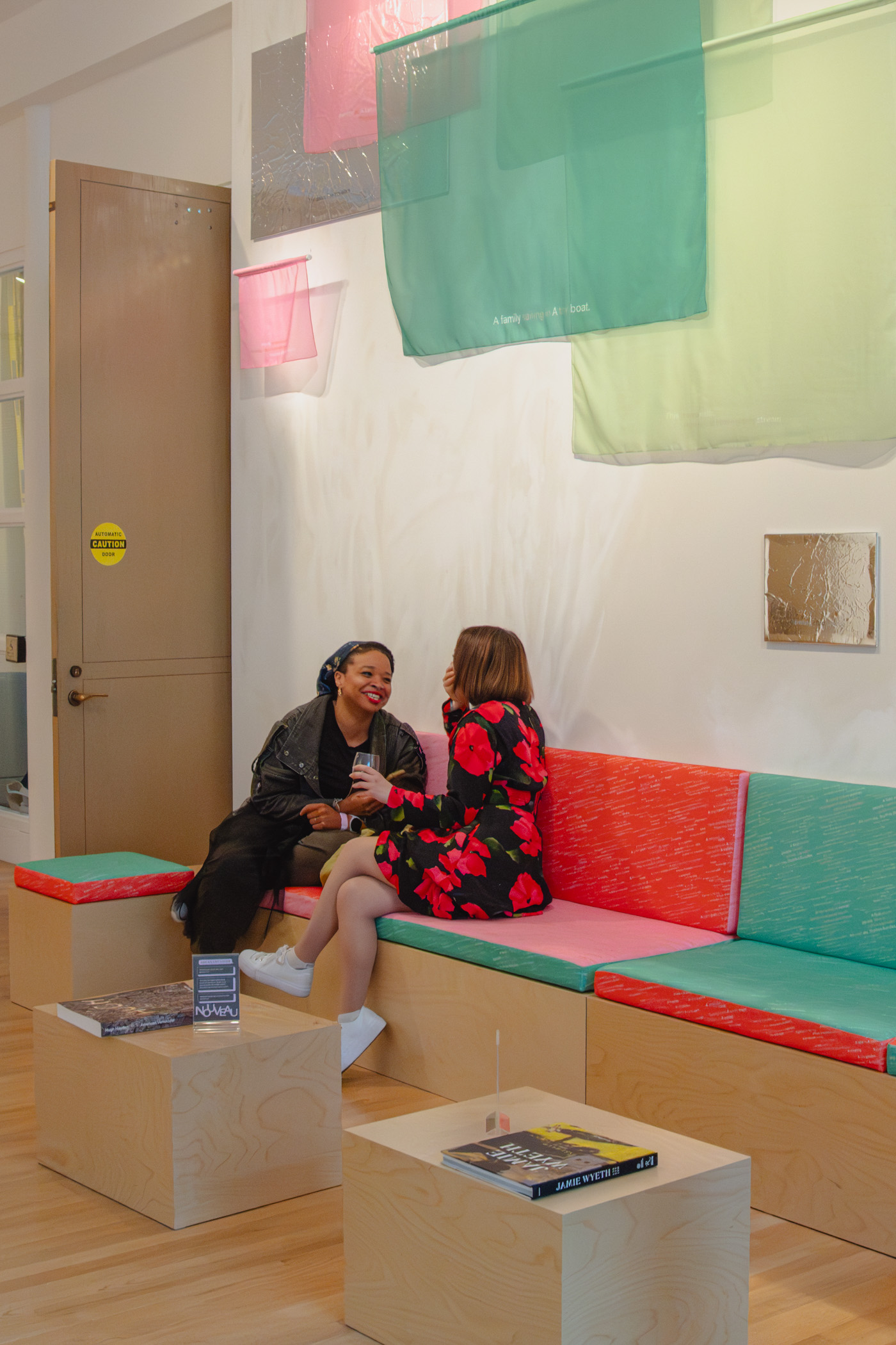 People chatting and smiling while seated on colorful benches
