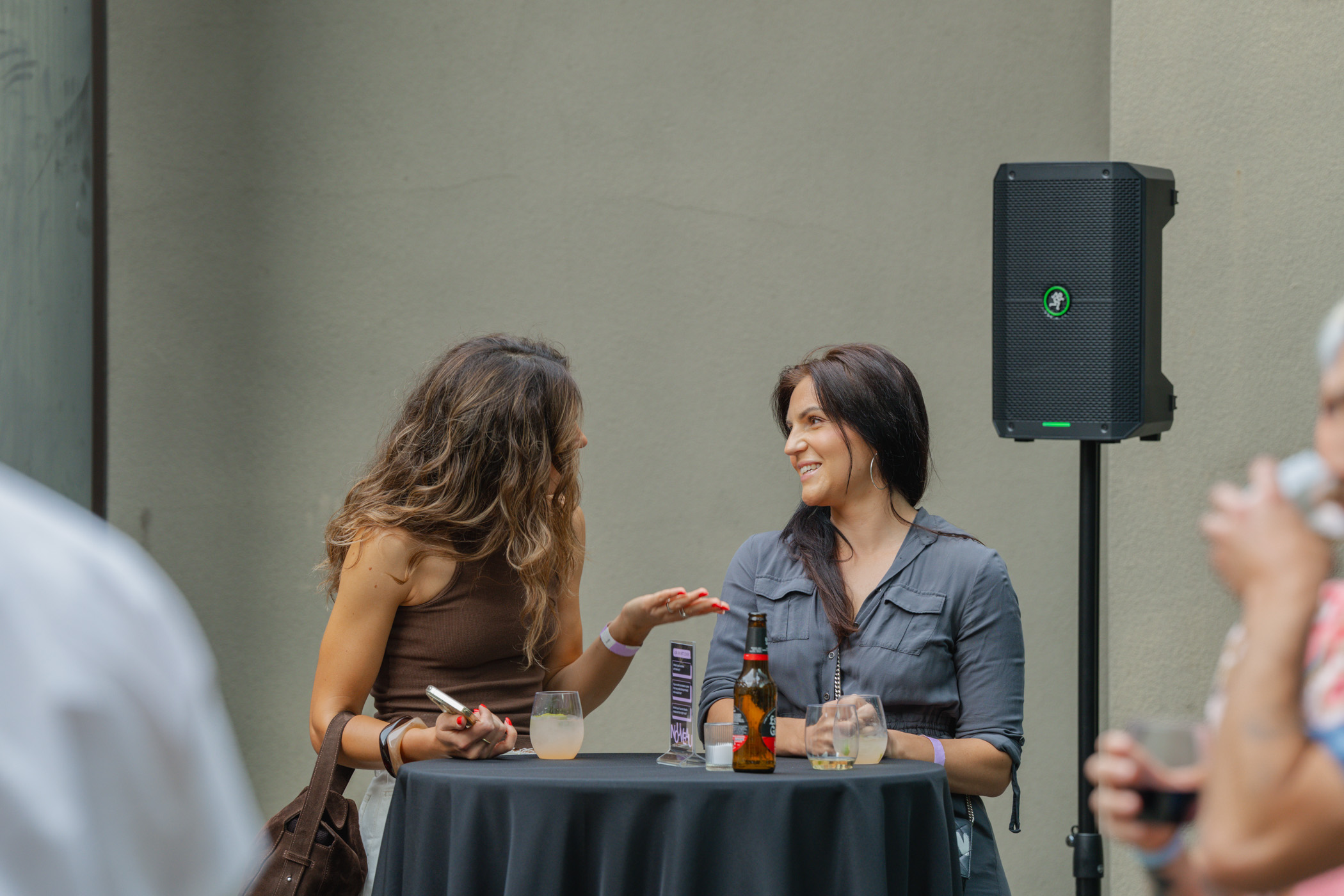 People standing at a tall banquet table while chatting