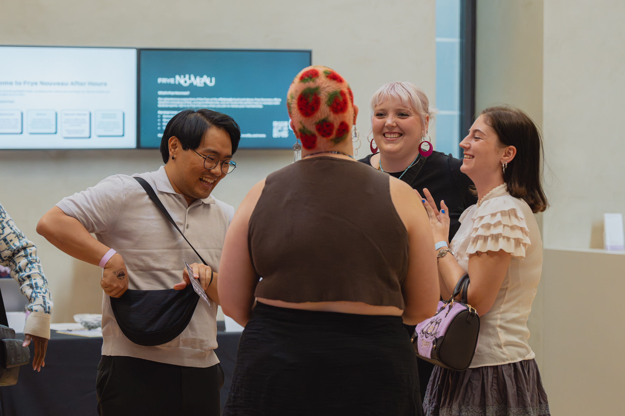 A group of young people smiling and greeting each other