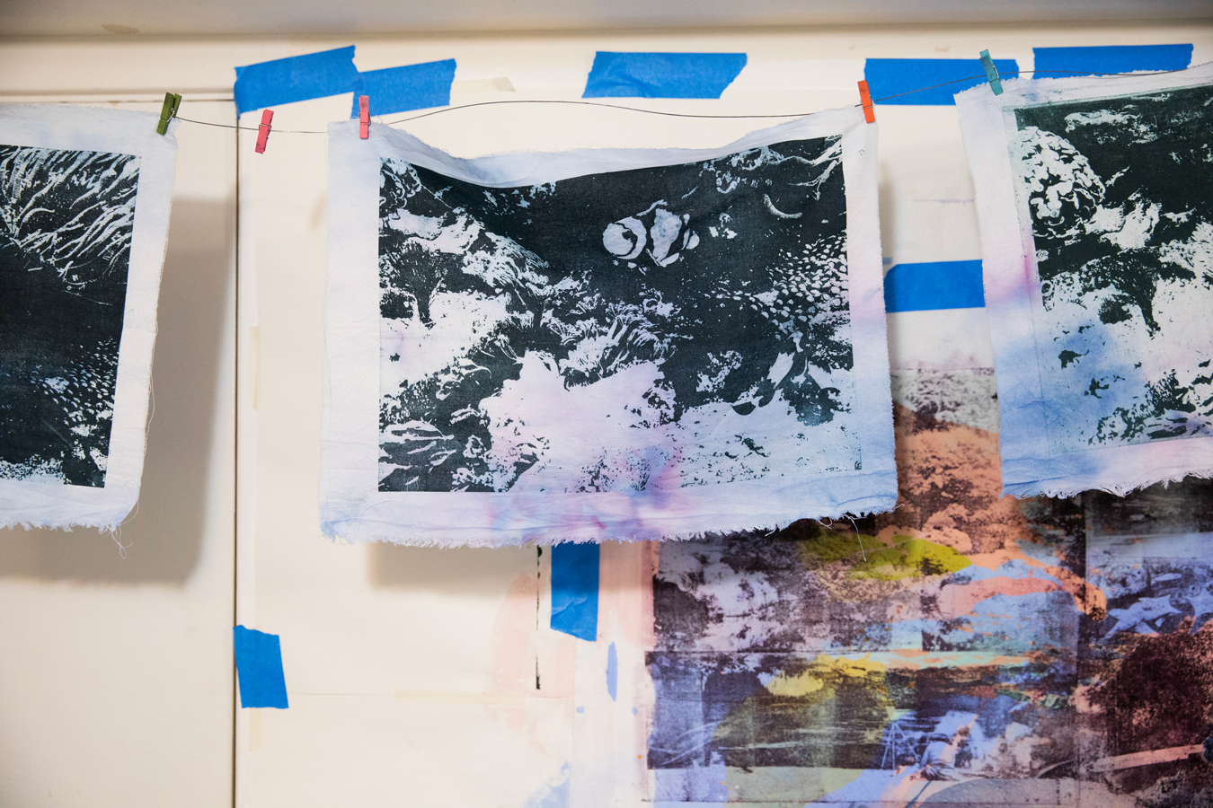 Photo of paper lithography on muslin fabric hanging from a wire