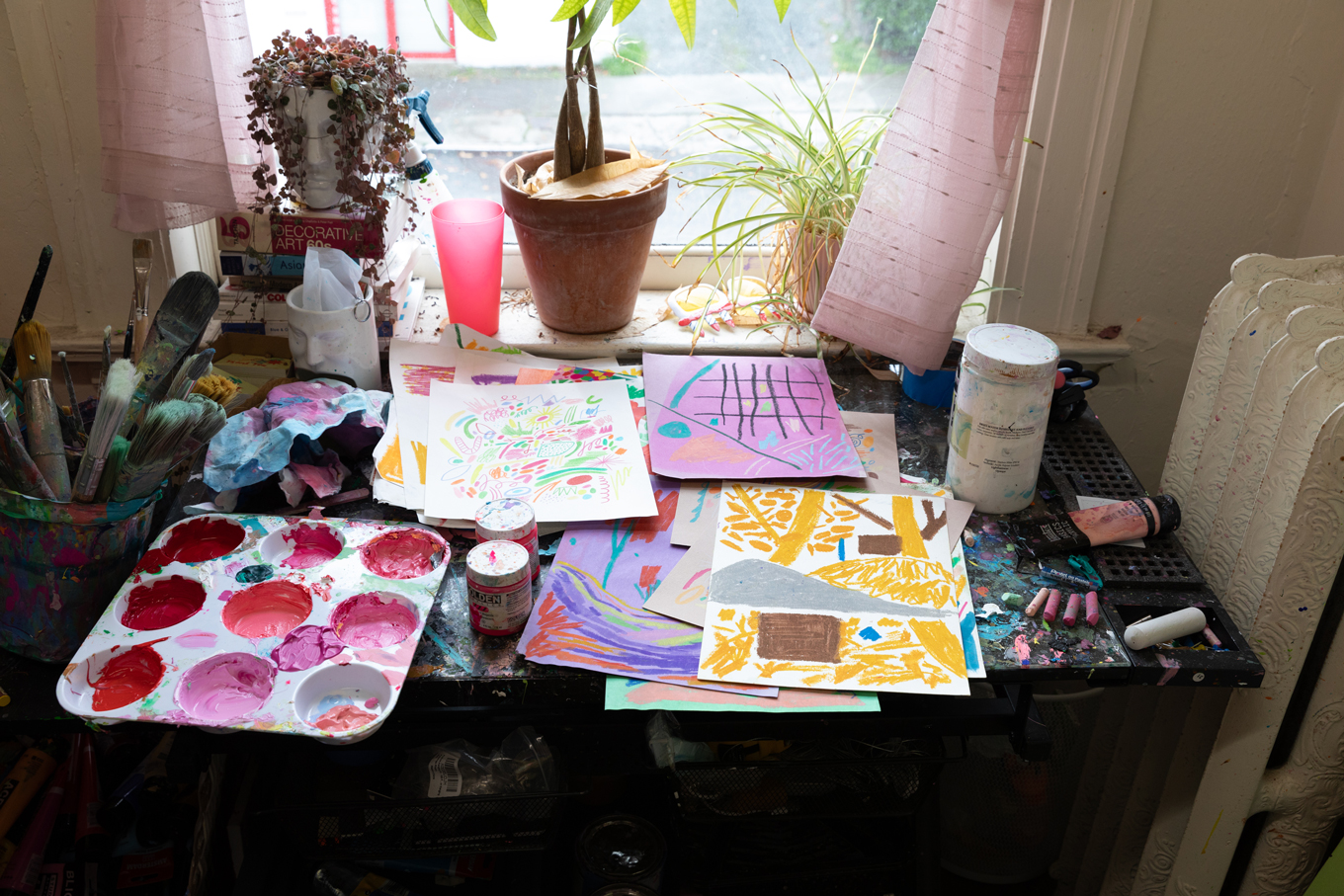 Photo of a table covered in brightly colored paintings