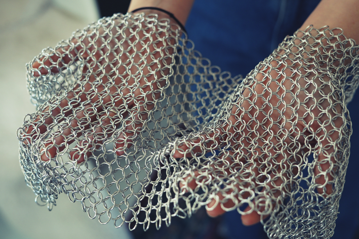 Photo of hands holding a piece a chainmail