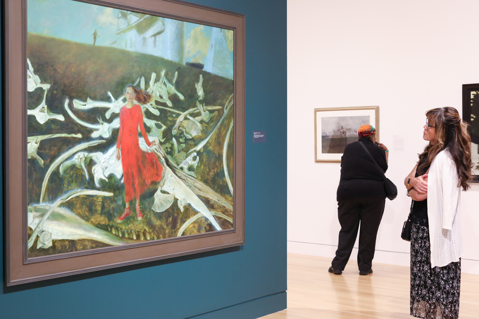 Woman in a white sweater looking at a Jamie Wyeth painting