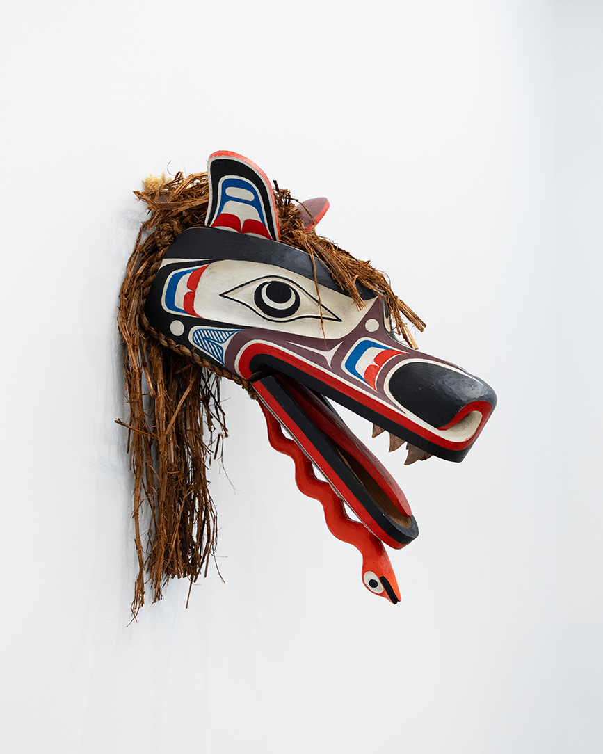 A blue, white, and red Pacific coast native wooden mask in the form of a 
