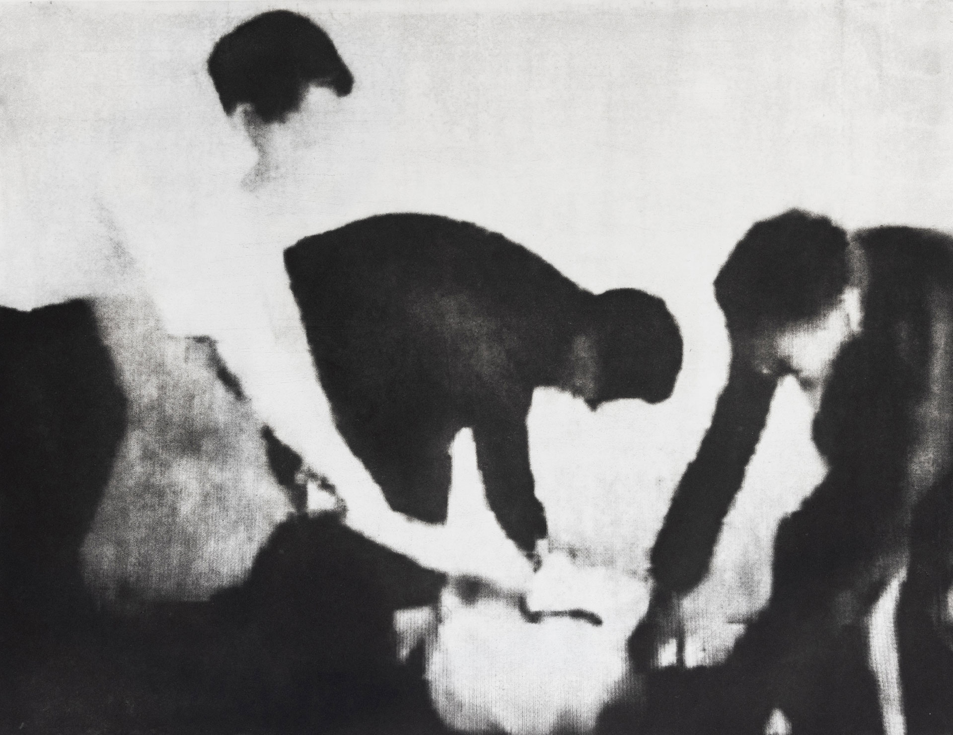 Black and white photo of three people holding down another person on the ground