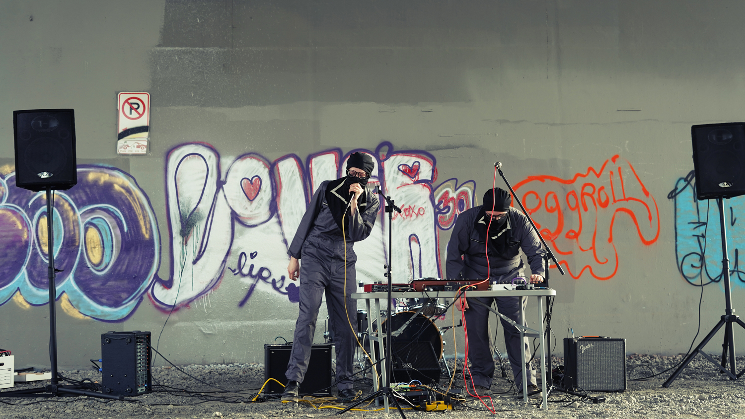 Photo of two people of the band Scum Wife performing outside