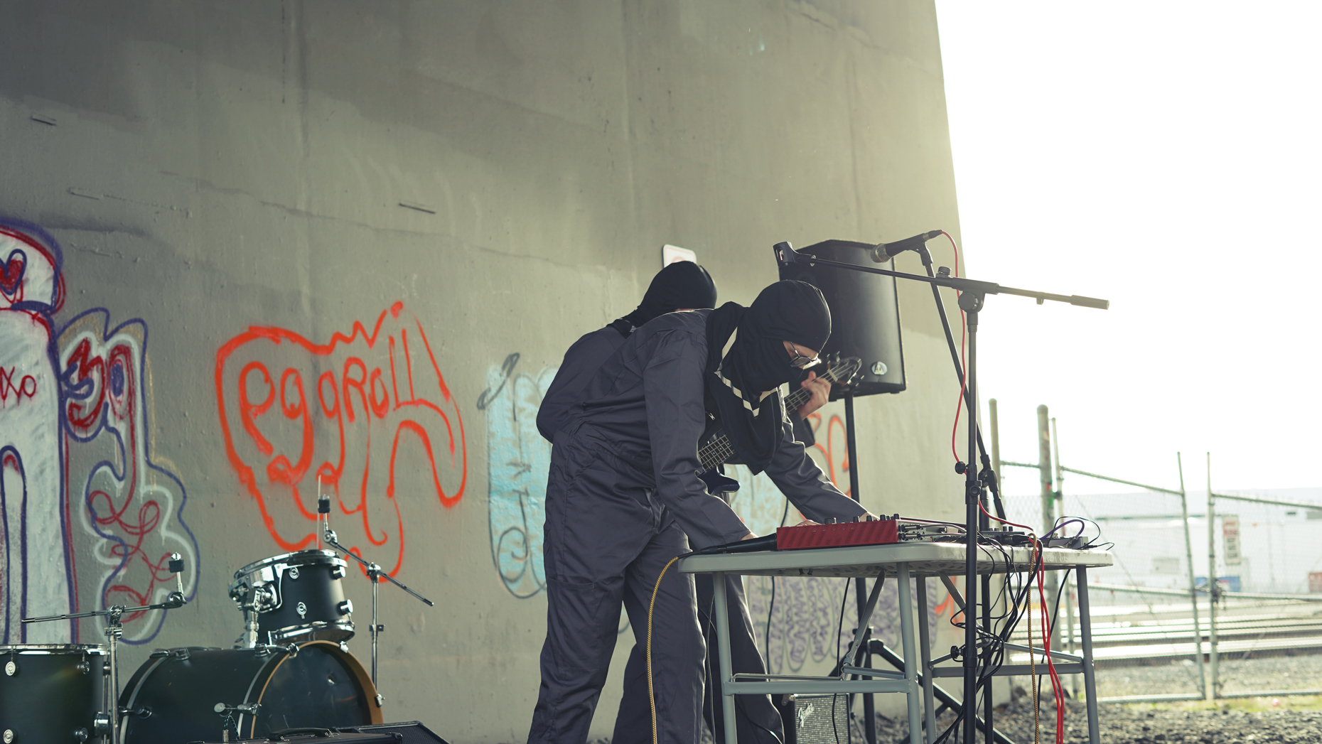Photo of two people of the band Scum Wife performing outside