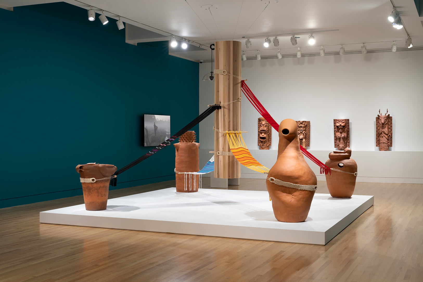 A large room with a central sculptural artwork made of fabric and ceramic