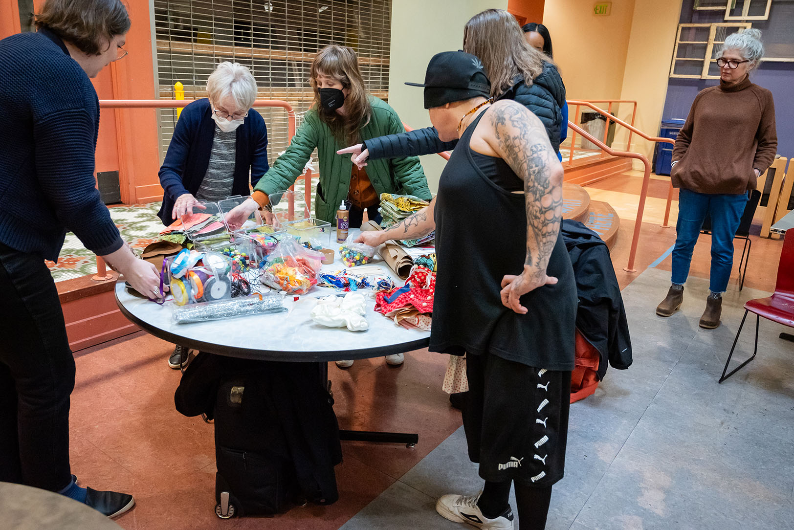 People standing around a table choosing crafting materials
