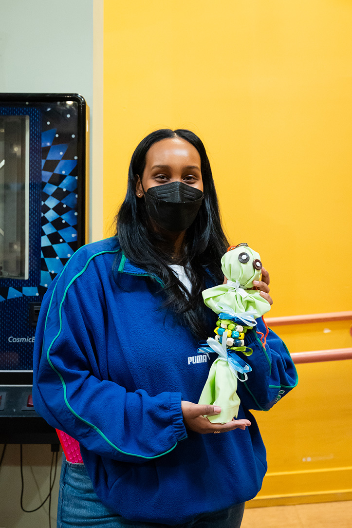A person holding a doll made from crafting materials