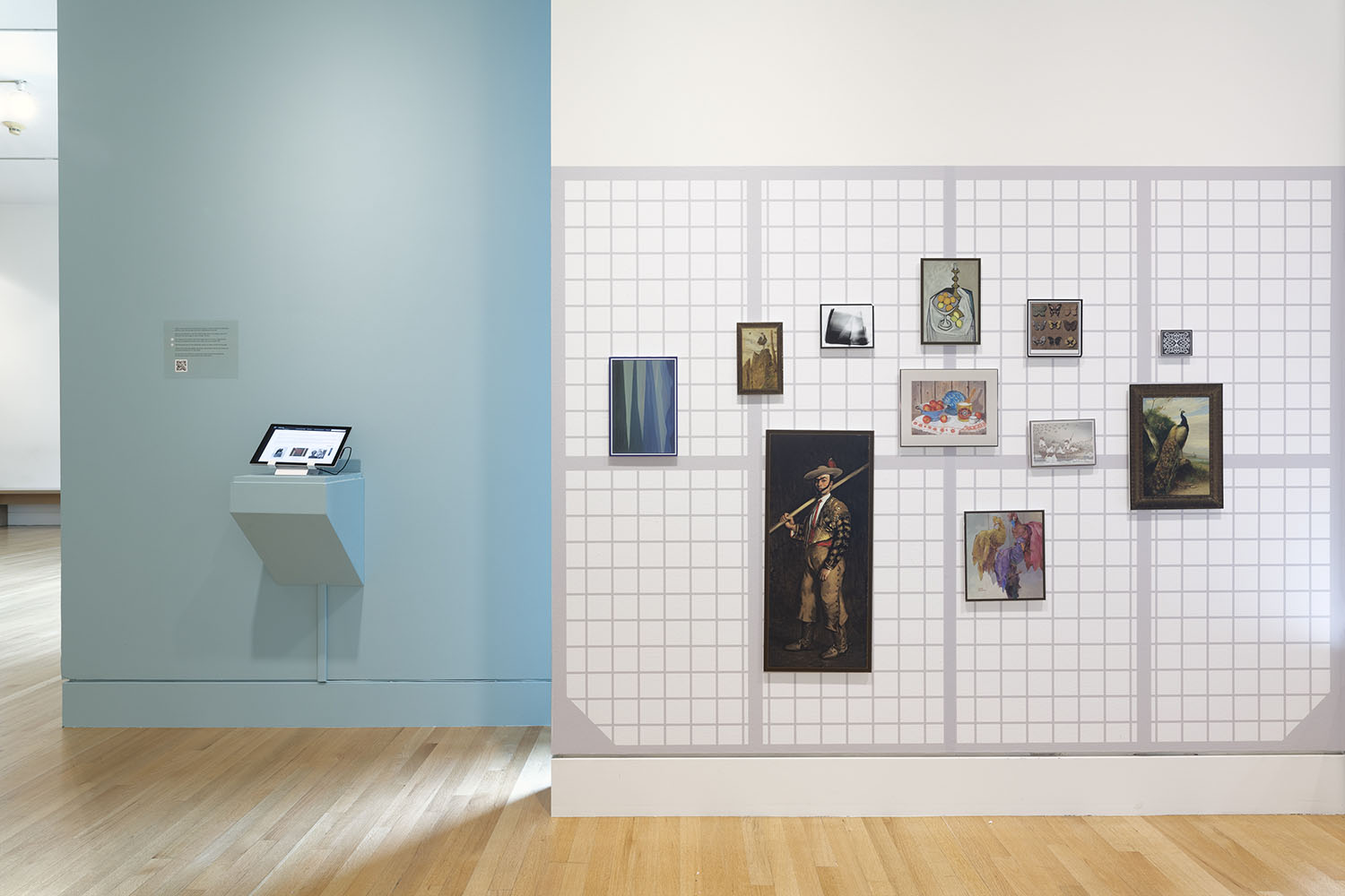 Magnetic artwork reproductions and tablet on grey and white museum gallery walls