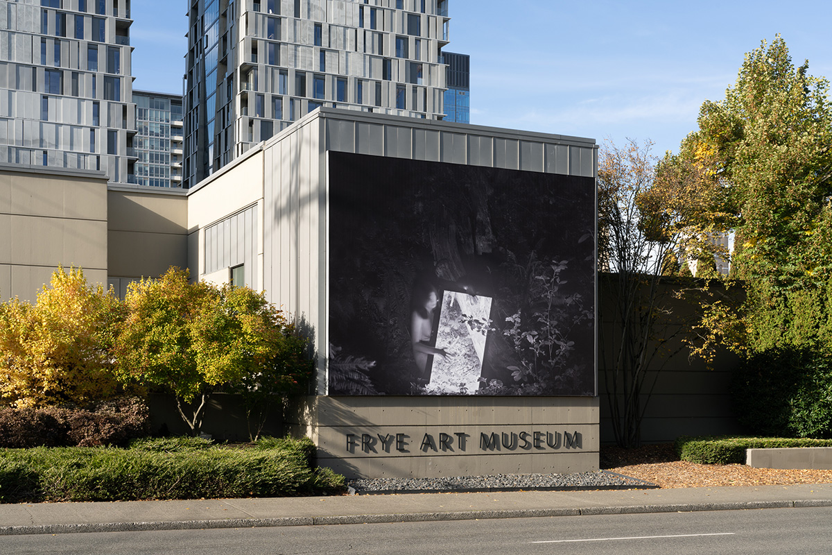A large black and white photographic banner install on the outside of a building above the text 'Frye Art Museum'