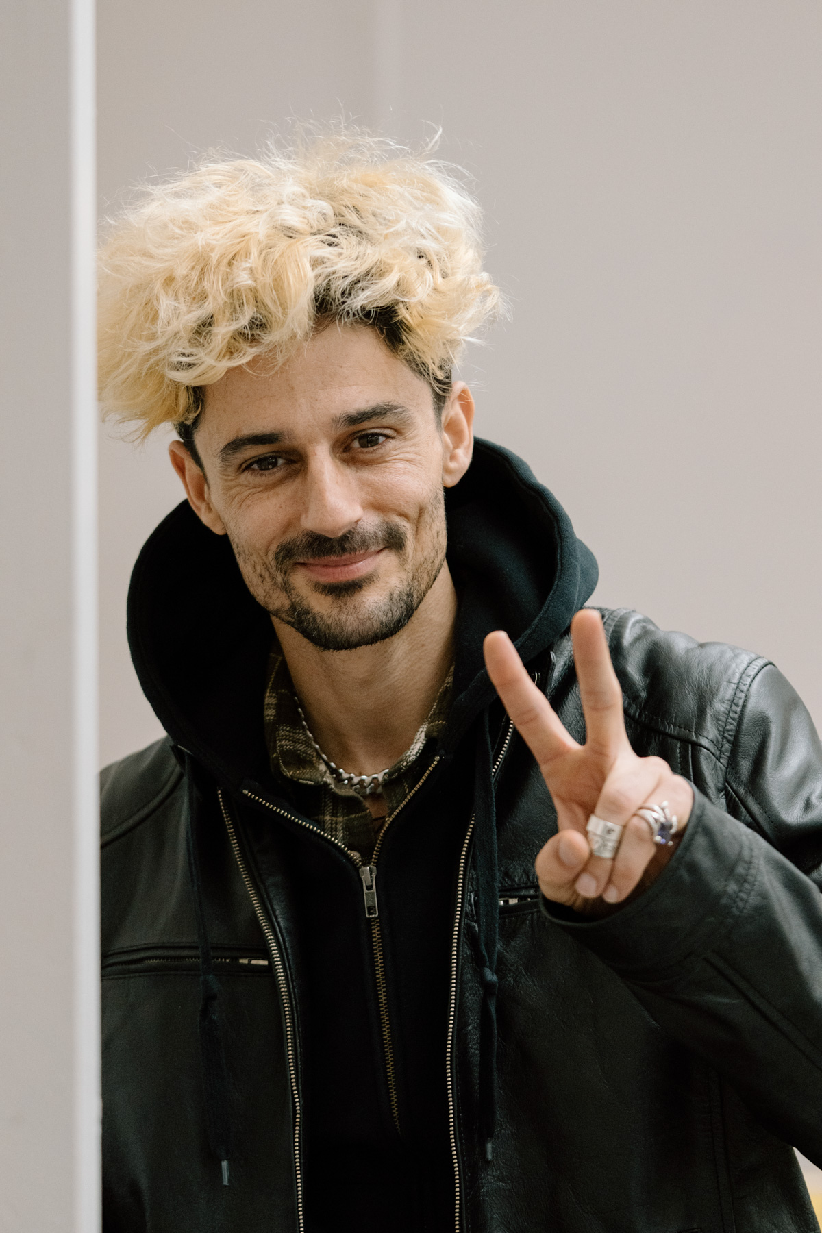 A person smiling and making a peace sign