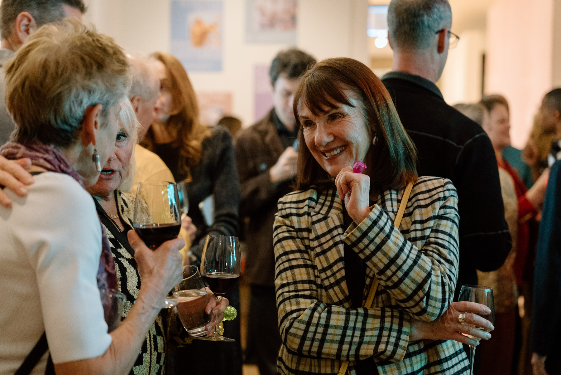 People smiling and talking while holding drinks