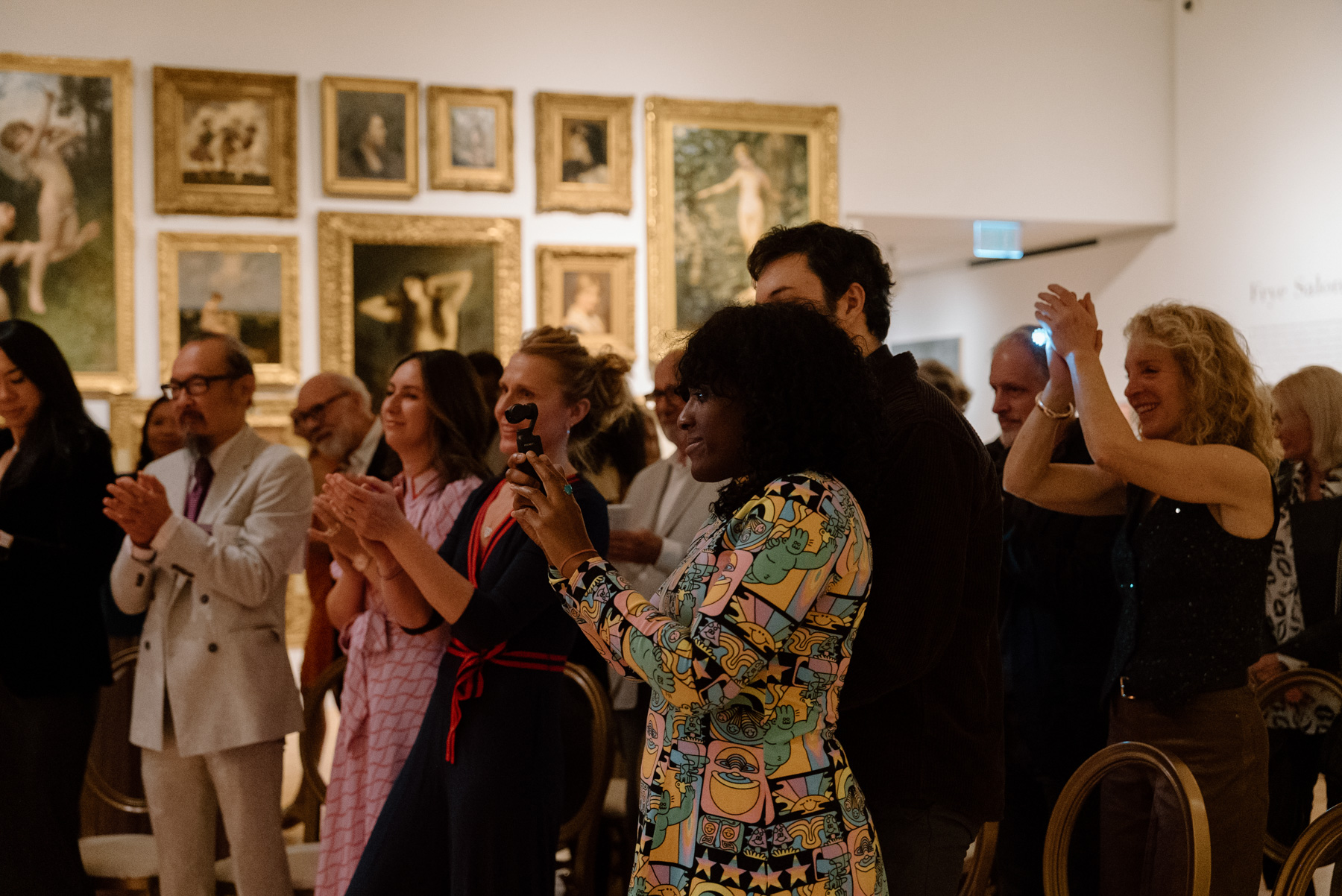 People smiling and clapping while watching a performance