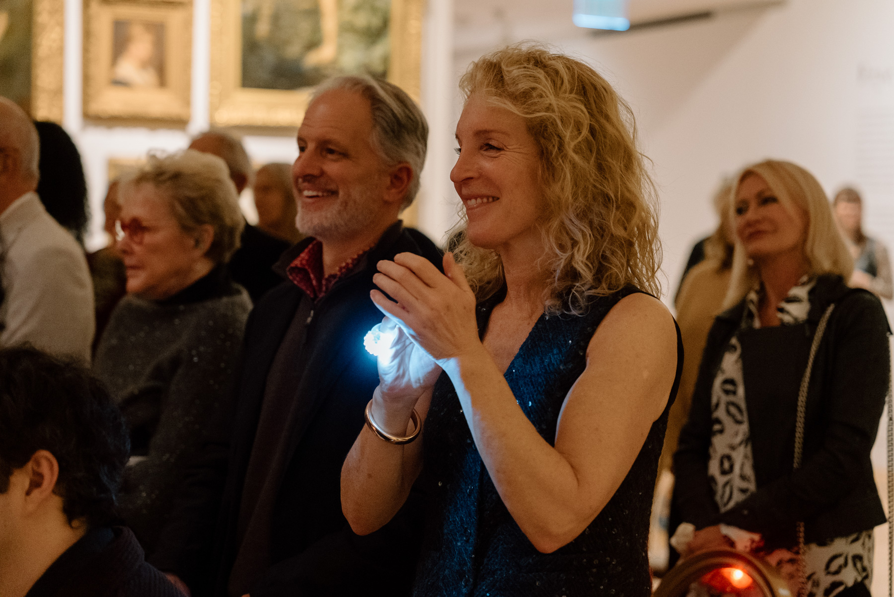 People smiling and watching a performance