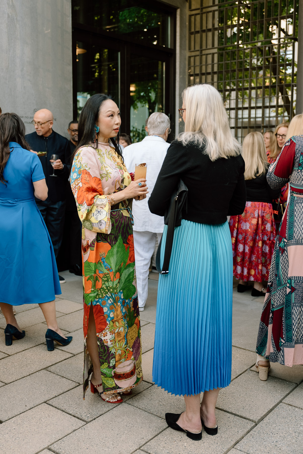Two woman in colorful clothes standing and chatting in a courtyard