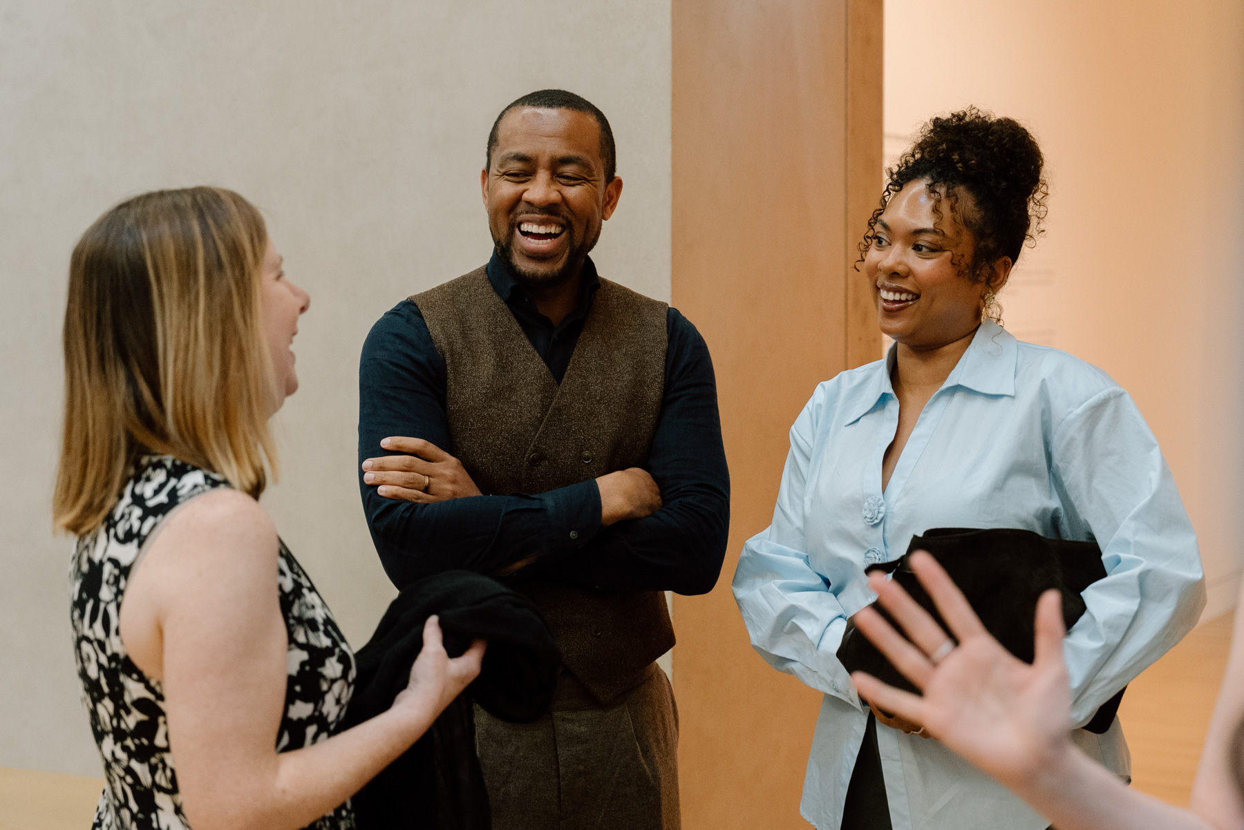 Three people smiling and chatting