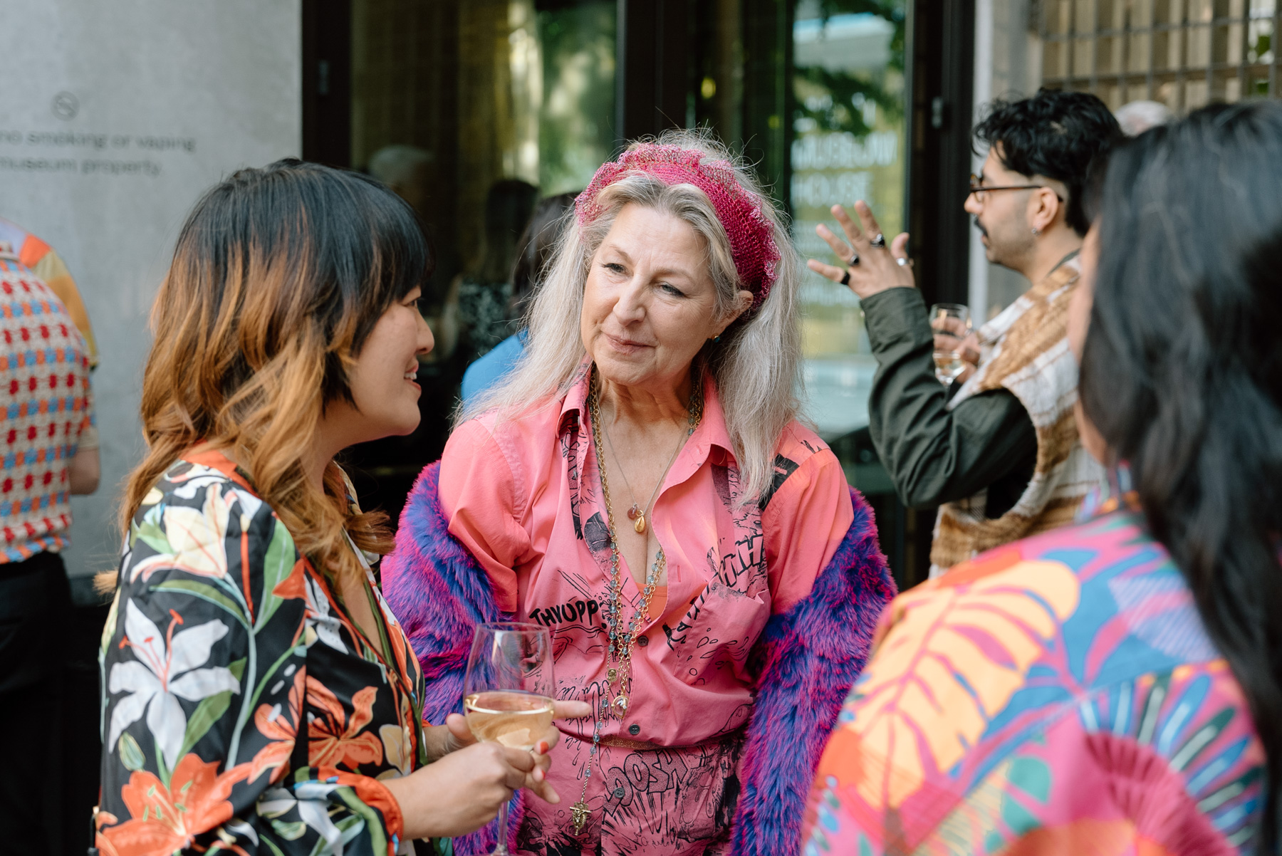 People in colorful clothes smiling and chatting in an outdoor space