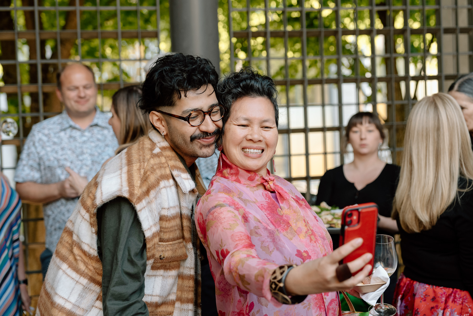 Two people posing while one holds a camera out to take a selfie