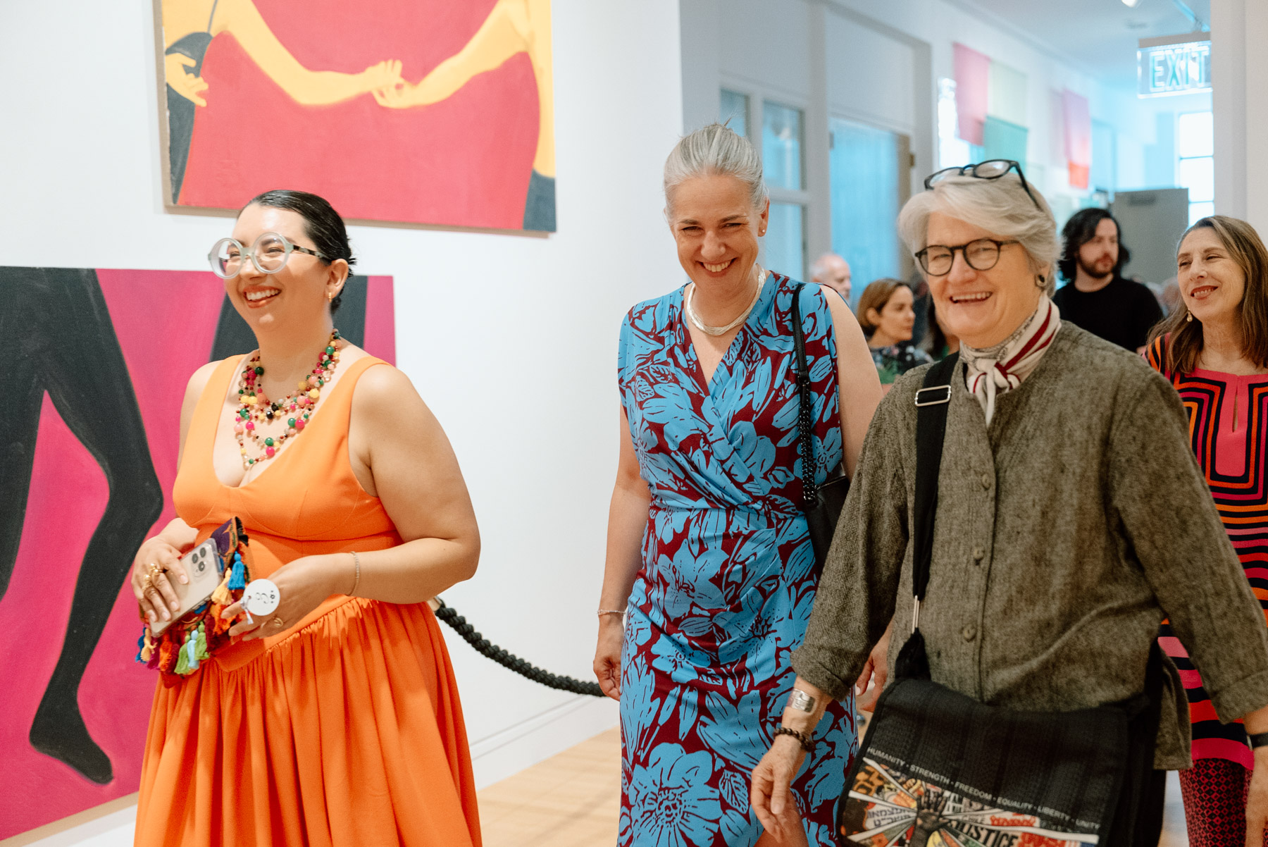 Three people laughing and walking down a hallway