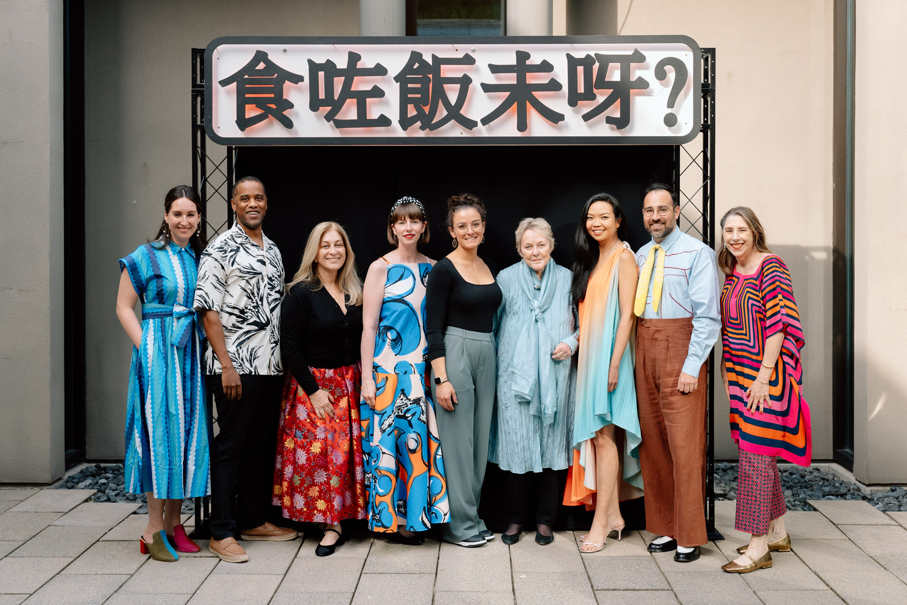 People posing in front of a sign with Chinese characters