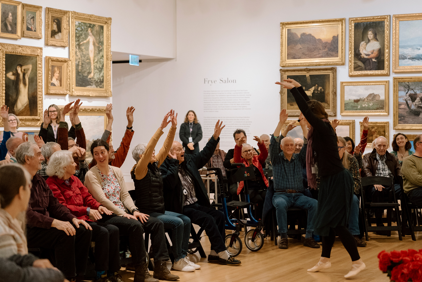 Dr. Julia Becke leads seated movement with a group of participants in the Frye Salon