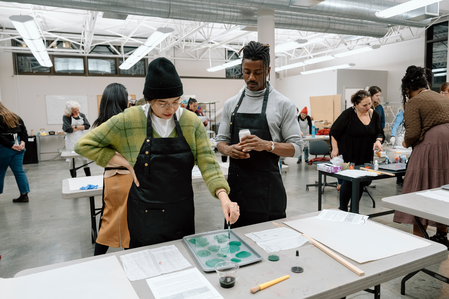 Two people doing a marbling workshop in the Studio
