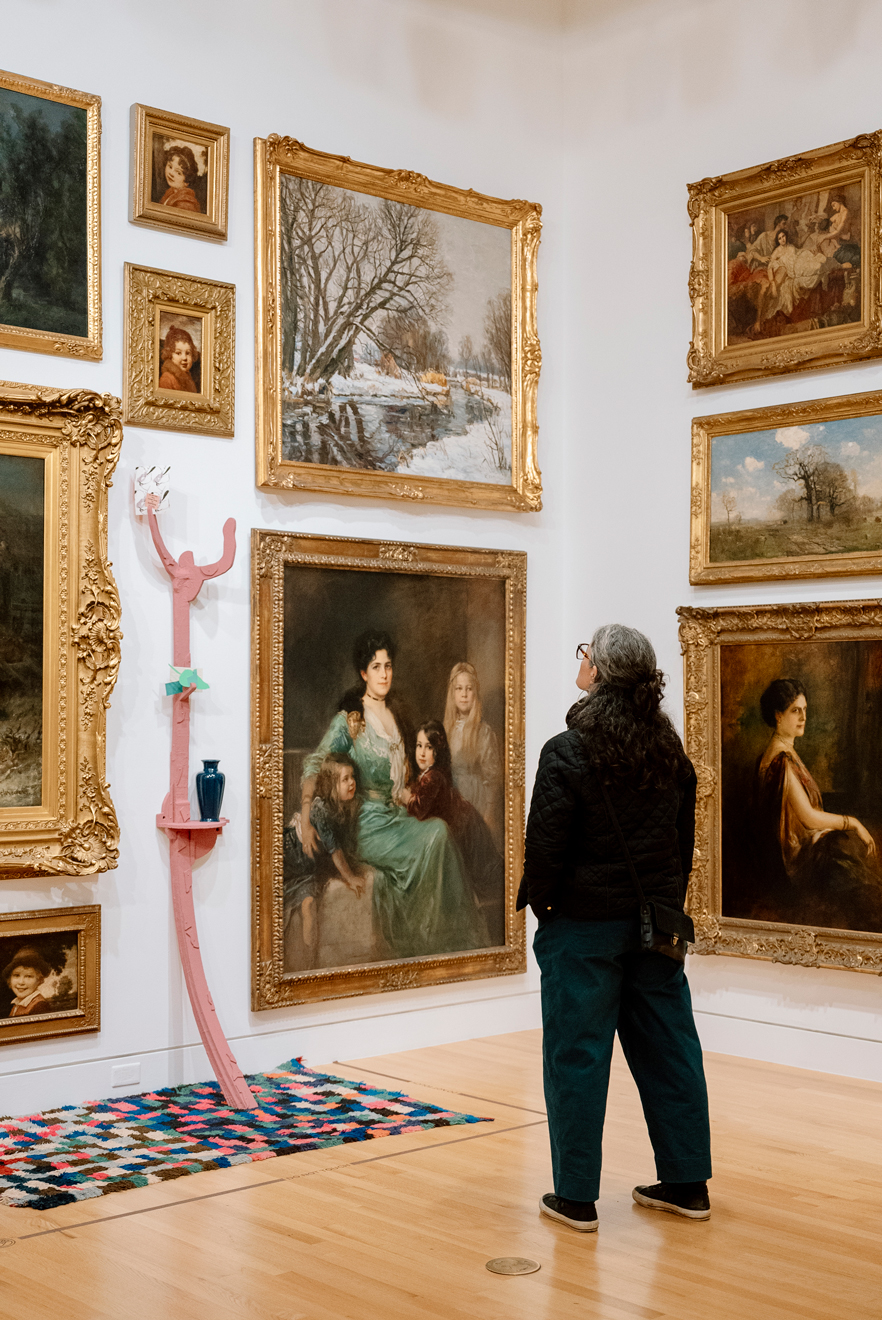 Person looking at both Founding collection and contemporary artworks in the Frye Salon