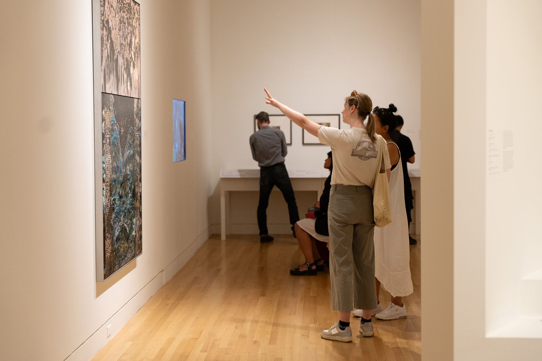 People looking at and pointing out art in the galleries at the Frye