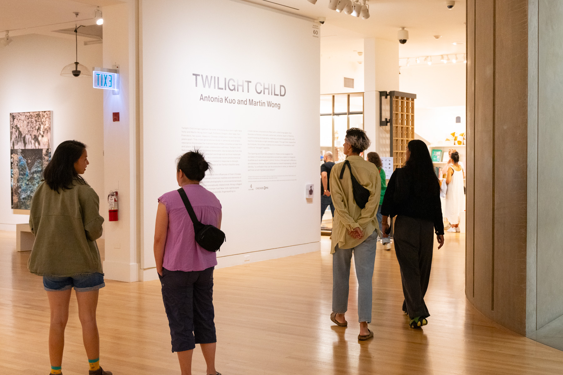 People walking through the Frye galleries and looking at an exhibition title wall