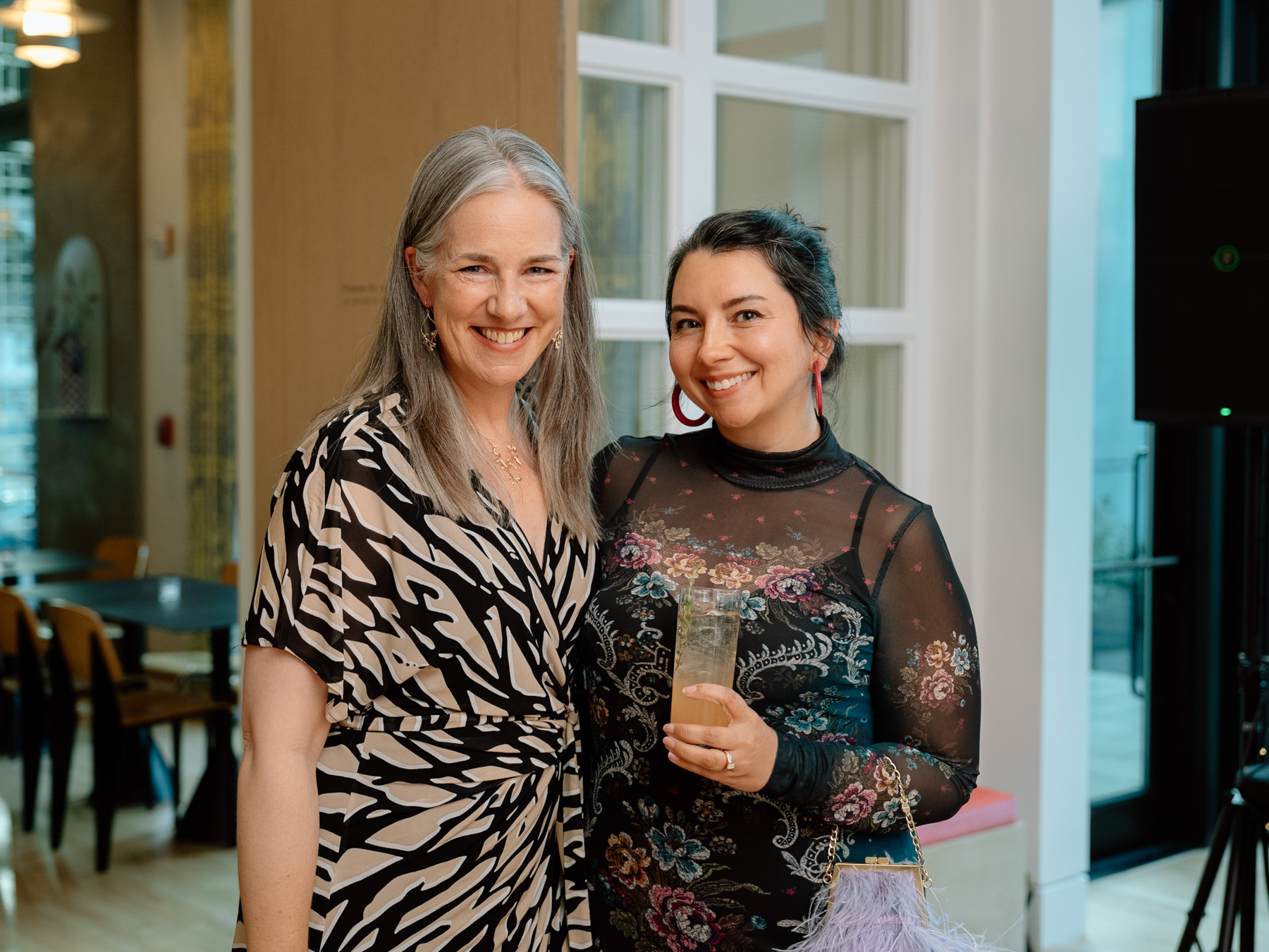 Two people in cocktail party attire posing together and smiling