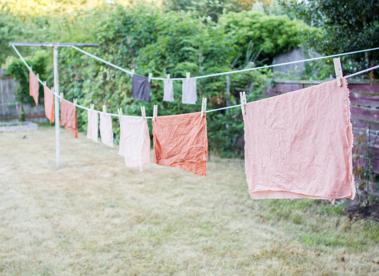 Photo of naturally dyed fabric drying on a clothesline outside