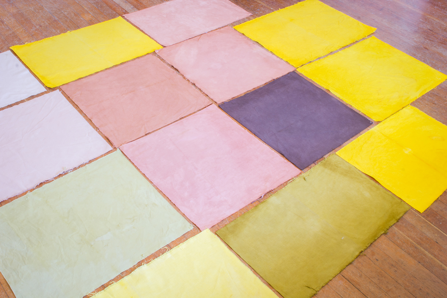 Photo of naturally dyed fabric laid out on a floor