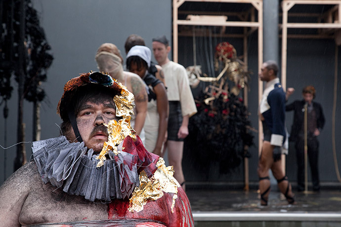 A person in costume in front of performers in the Frye Art Museum reflecting pool